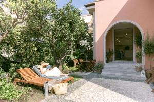 a woman sitting on a bench outside of a house at Ca' de Ma in Diano Marina