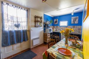 une cuisine avec des murs bleus et une table dans l'établissement Le petit secret, à Saint-Aignan