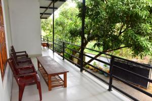 d'un balcon avec une table, des chaises et un arbre. dans l'établissement Lion Home Stay Anuradhapura, à Anurâdhapura
