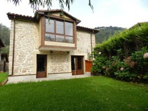 ein Haus mit einem großen Fenster auf einem Hof in der Unterkunft Apartamento en Cantabria, Treceño in Treceño