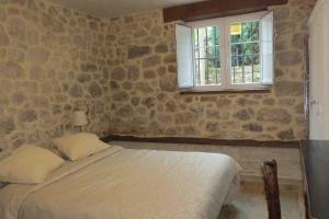 a bedroom with a bed and a stone wall at Apartamento en Cantabria, Treceño in Treceño