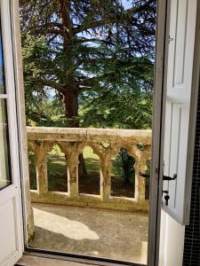 eine offene Tür mit Blick auf einen Steinzaun in der Unterkunft Château Fauchey in Cardan