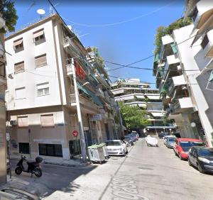 uma rua com carros estacionados ao lado de um edifício em Luxury apartment in Sepolia em Atenas