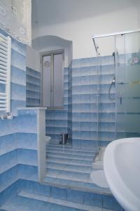 ein blau gefliestes Bad mit einer Dusche und einem Waschbecken in der Unterkunft CASA Candida in Genua