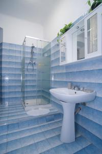 ein blau gefliestes Bad mit einem Waschbecken und einer Dusche in der Unterkunft CASA Candida in Genua