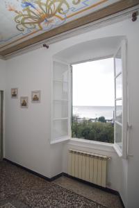 Zimmer mit einem großen Fenster und Meerblick in der Unterkunft CASA Candida in Genua