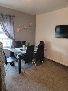 a dining room with a table and chairs and a television at Elegance apartments in West Cornforth