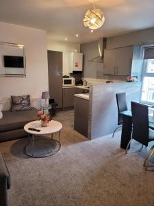 a living room with a couch and a table at Elegance apartments in West Cornforth