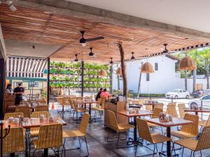 un restaurante con techos de madera, mesas y sillas en Nereidas Lofts, en Bucerías