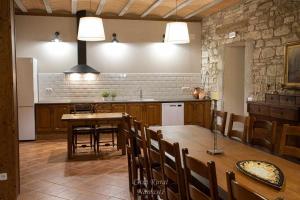 eine Küche mit einem Holztisch und Stühlen sowie eine Küche mit in der Unterkunft Casa Rural Namasté con SPA in Lleida