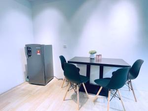 a table and chairs in a room with a refrigerator at Pavilion 2 Revo l Rooftop Swimming Pool LS15 in Kuala Lumpur