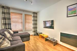 a living room with a couch and a flat screen tv at 5 Argyle Place in Dornoch