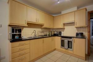 una cucina con armadietti in legno ed elettrodomestici di 5 Argyle Place a Dornoch