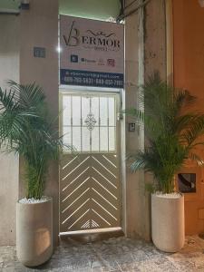 two potted plants sitting in front of a door at VBermor Hotel in Santo Domingo