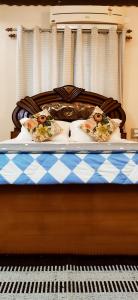 una cama con una sábana a cuadros azul y blanco y un piano en Estancia Tranquila's Casa de la Abuela en Pondicherry