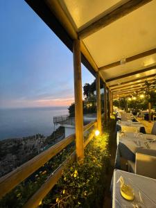 a restaurant with a view of the ocean at night at Fico D'India Relais in Furore