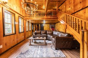 a living room with a leather couch and a table at Peaceful cabin w/ hot tub, pool table & fire pit - BIG BLUE in Bryson City