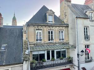een oud gebouw met een balkon in een stad bij La Verrière Saint-Martin - Historic Center & WIFI in Bayeux