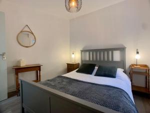 een slaapkamer met een groot bed met 2 blauwe kussens bij La Verrière Saint-Martin - Historic Center & WIFI in Bayeux