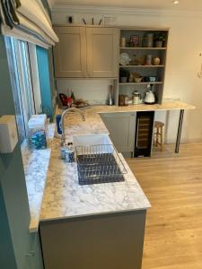 a kitchen with a counter top with a sink at Wogan Cottage in Saundersfoot +7 photos