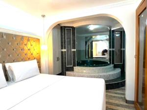 1 dormitorio con bañera, cama y espejo en Lavid Hotel Kennedy en Bogotá