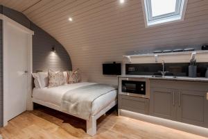 a bedroom with a bed and a kitchen with a sink at The Gamekeeper's Inn in Skipton