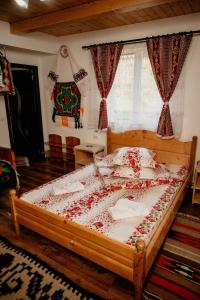 1 dormitorio con 1 cama grande cubierta de rosas rojas en Casa Pintea de Sub Coastă en Breb