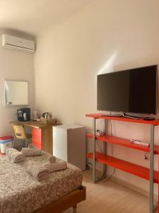 a room with a bed and a flat screen tv at Casa del Sole in Foggia