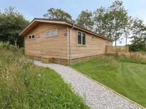 a large wooden cabin in a field of grass at 18 Meadow Retreat in Liskeard