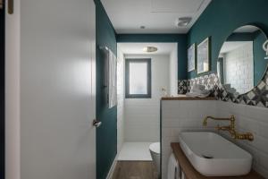 ein Badezimmer mit Waschbecken, Toilette und Spiegel in der Unterkunft Wello Apartments Sevilla in Sevilla + 41 Fotos