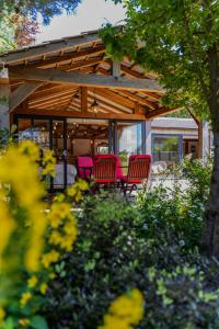 een patio met rode stoelen en een tafel voor een huis bij The Cabin in Fareham