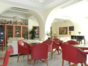 a dining room with red chairs and tables at Hotel Il Mulino in Capo dʼOrlando