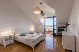 a white bedroom with a bed and a large window at Soul house POLA in Split