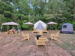 a group of picnic tables and tents in a field at Tentrr Signature Site - Glamping in The Hamptons in Hampton