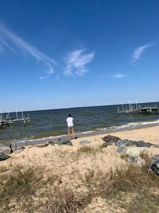 Ein Mann steht am Strand in der Nähe des Ozeans in der Unterkunft Tentrr Signature Site - Potomac Landing in Heathsville