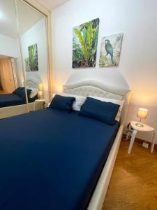 a bedroom with a blue bed and a mirror at Colosseum Charming Stay in Rome