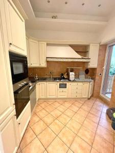 a kitchen with white cabinets and a tile floor at Colosseum Charming Stay in Rome