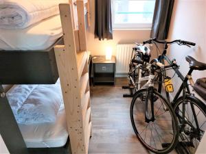 een kamer met 2 stapelbedden en een fiets bij Luxe cottage met fietsen, airco & infrarood cabine in Knokke-Heist