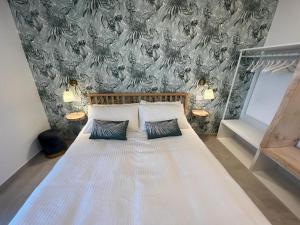 una camera da letto con un grande letto bianco con due cuscini di Villa Lattea ad Acitrezza