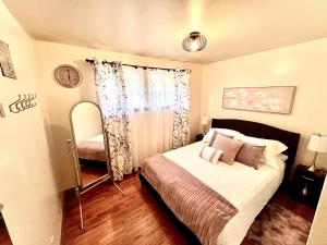 a small bedroom with a bed and a mirror at Charming Home Away from Home in Thunder Bay
