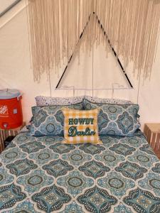 a bed with a pillow that reads honeydewdar at Tentrr Signature Site - The Nest in Bluff City