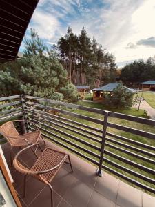 een balkon met 2 stoelen en een hek bij Hotel Załęcze in Pątnów