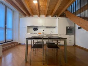 eine Küche mit einem Tisch und Stühlen im Zimmer in der Unterkunft Riso e Latte Casa Vacanze in Pisogne
