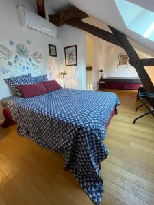 1 dormitorio con 1 cama con edredón azul en Gîte de la Mignonerie du Château de Jallanges pour 19 personnes avec 4 ou 7 chambres, en Vernou-sur-Brenne