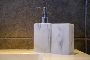 a white soap dispenser sitting on top of a sink at Bed and breakfast Mentari in Ghent