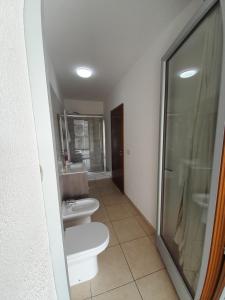 een badkamer met 2 toiletten en een douche bij jolly casa 2 in Cosenza