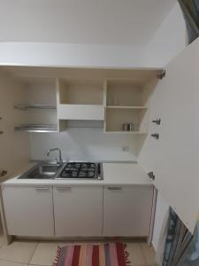 a white kitchen with a sink and a stove at jolly casa 2 in Cosenza
