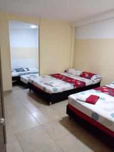 a group of three beds in a room at montecarlos hotel in Ibagué