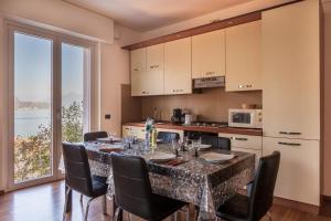 une salle à manger avec une table et des chaises ainsi qu'une cuisine dans l'établissement Appartamento Sosta sul Lago, à Lezzeno