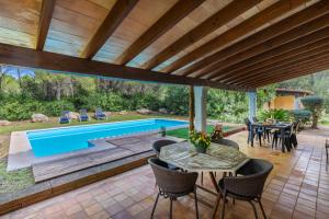 an outdoor patio with a pool and tables and chairs at Villa Mireia in Pollença